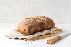 Loaf of bread, and knife, on delicate  background. Front view. Copy space.