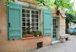 Window with open shutters and door in provence style and tiffany color with original lantern in the form of an old inverted watering can over the door