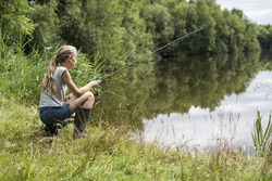 girl fishing at lake in summer vacation