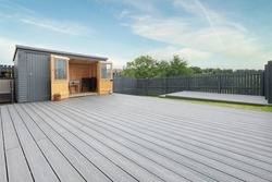 Ash grey composite decking built on two levels on a residential back garden with low voltage deck lights installed as well. Good Image for a landscape Gardiner