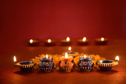 Beautiful diwali lamps with flowers on red background, Diwali Diya