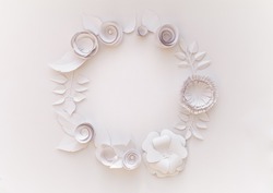 Round frame with white paper flowers on white background. Cut from paper.