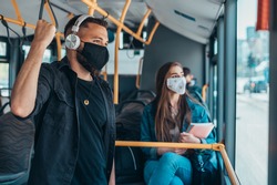Passengers wearing protective mask while riding a bus and keeping the distance due to a corona virus pandemic