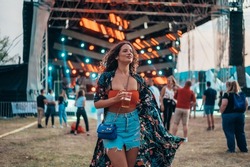 Beautiful woman drinking beer and having fun on a festival with her friends