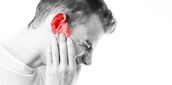 Tinnitus,  man on a white background holding a sick ear, suffering from pain