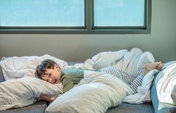 Adorable little boy lying in bed. people, children, rest and comfort concept. Soft focus. Copy space.
