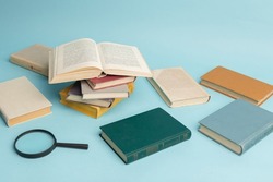 Vintage books and magnifying glass on light blue background. Education background. World books day.
