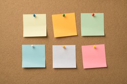Photo of different colorful memo papers attached with pins to the wooden board
