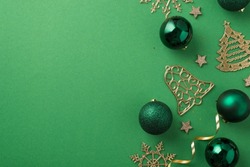 Top view photo of christmas decorations small glowing stars green balls gold serpentine sequins fir jingle bell and snowflake ornaments on isolated green background with blank space