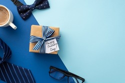 Father's Day concept. Top view photo of craft paper giftbox with ribbon bow and postcard cup of coffee glasses blue necktie and bow-tie on bicolor blue background with copyspace