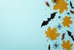 Halloween decor concept. Top view photo of gold sparkle maple leaves bat silhouettes creepy insects spiders cockroach centipedes and confetti on isolated pastel blue background with copyspace