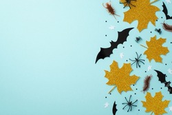 Halloween creepy decor concept. Top view photo of gold sparkle maple leaves bat ghost silhouettes insects spiders cockroach centipedes and confetti on isolated pastel blue background with empty space