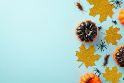 Halloween creepy decorations concept. Top view photo of pumpkins gold sparkle maple leaves spiders cockroach and centipede on isolated pastel blue background with empty space