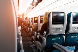 Soft focus and blurred background of passengers on commercial aircraft ,airplane or plane that  airplane cabin interior with seats,air transport is the current popular and fast with lighting.