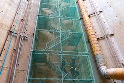 Step zigzag staircase safety with net fall-protection in underground construction site or fire escape, a ladder or stairs outside a building that allow people in the building to escape a fire.