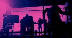 Behind the scenes of shooting video production and lighting set for filming movie which film crew team working in silhouette and professional equipment in studio for video. video production concept.