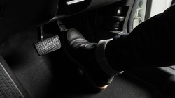 Accelerator and breaking pedal in a car. Close up the foot pressing foot pedal of a car to drive ahead. Driver driving the car by pushing accelerator pedals of the car. inside vehicle. 