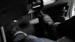 Close up the foot pressing foot pedal of a car to drive. Accelerator and brake pedal in a car. Driver driving the car by pushing accelerator and break pedals of the car. inside vehicle. control pedal.