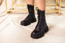 Black women's boots made of genuine leather. New collection of winter shoes for stylish girls. Fashionable women's stylish leather boots.