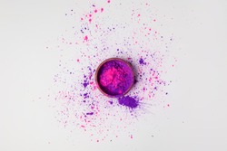 top view of purple and pink holi powder in bowl isolated on white