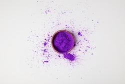 top view of purple holi paint in bowl isolated on white, festival of colours