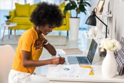 side view of smiling african american female freelancer working at home