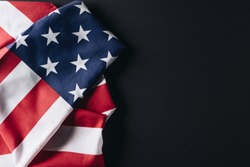 folded national flag of usa isolated on black, memorial day concept