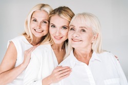 cheerful three generation blonde women isolated on grey