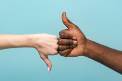 cropped view of interracial couple showing thumbs up isolated on blue