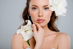 white blooming flowers near beautiful woman touching face isolated on grey