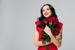 pleased woman holding roses isolated on grey