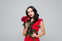 brunette young woman holding bouquet of roses isolated on grey