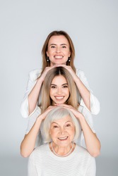 three generation of happy women isolated on grey