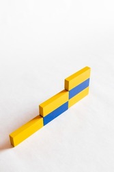 top view of stairs made of blue and yellow blocks on white background, ukrainian concept