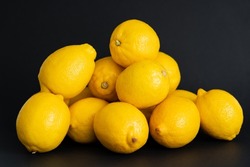 Heap of ripe yellow lemons isolated on black