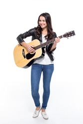 Full length portrait of young smiling woman playing guitar isolated on white