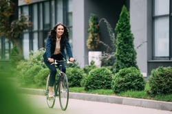 young happy businesswoman riding bicycle