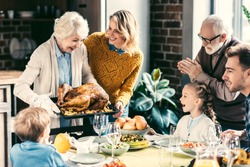 beautiful grandmother carrying turkey for family on thanksgiving dinner