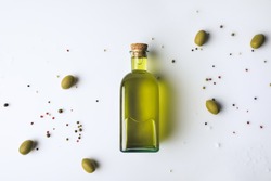 Top view of glass bottle with olive oil and olives isolated on white