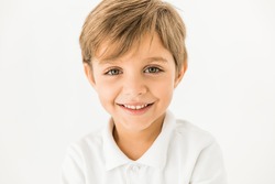close-up portrait of adorable happy little boy smiling at camera isolated on white