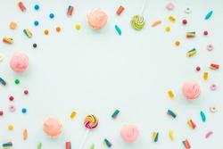 Colorful candies on pastel turquoise background. Flat lay, top view