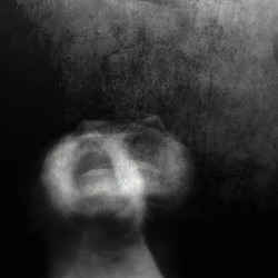 Scream of horror. Screaming woman face. Surreal portrait of a mysterious young woman. Black and white photo. Shot with long exposure.