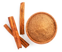 Cinnamon sticks and cinnamon powder in a plate on a white background, isolated. The view from top