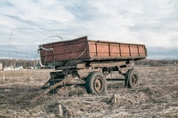 Old wagon in field, agriculture equipment. Abandoned carriage, farming machine