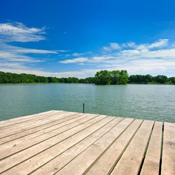 Wooden Pier on Lake under Blue Sky in Summer Landscape