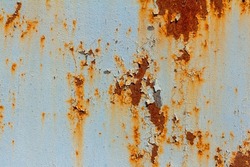 A rusty blue metal wall with fallen paint, a rusty background.