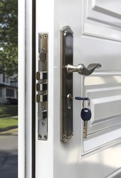 Open door of a family home. Close-up of the lock with your keys on an armored door.