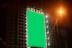 Green blank huge board on big city building in night town 
