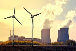 Nuclear power plant and wind turbines at sunset - Green energy concept