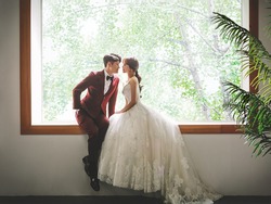 A beautiful, romantic and happy couple on their wedding day. Korean Asian male and female models. A bride in a gorgeous and beautiful wedding dress. Asian couple. 